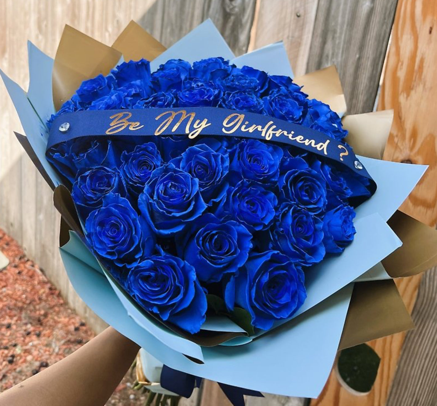 Bouquet of 12 sapphire-blue roses wrapped in navy and gold with a custom “Be My Girlfriend?” ribbon – Royal Love Confession by 1800 Blooms Bronx NY