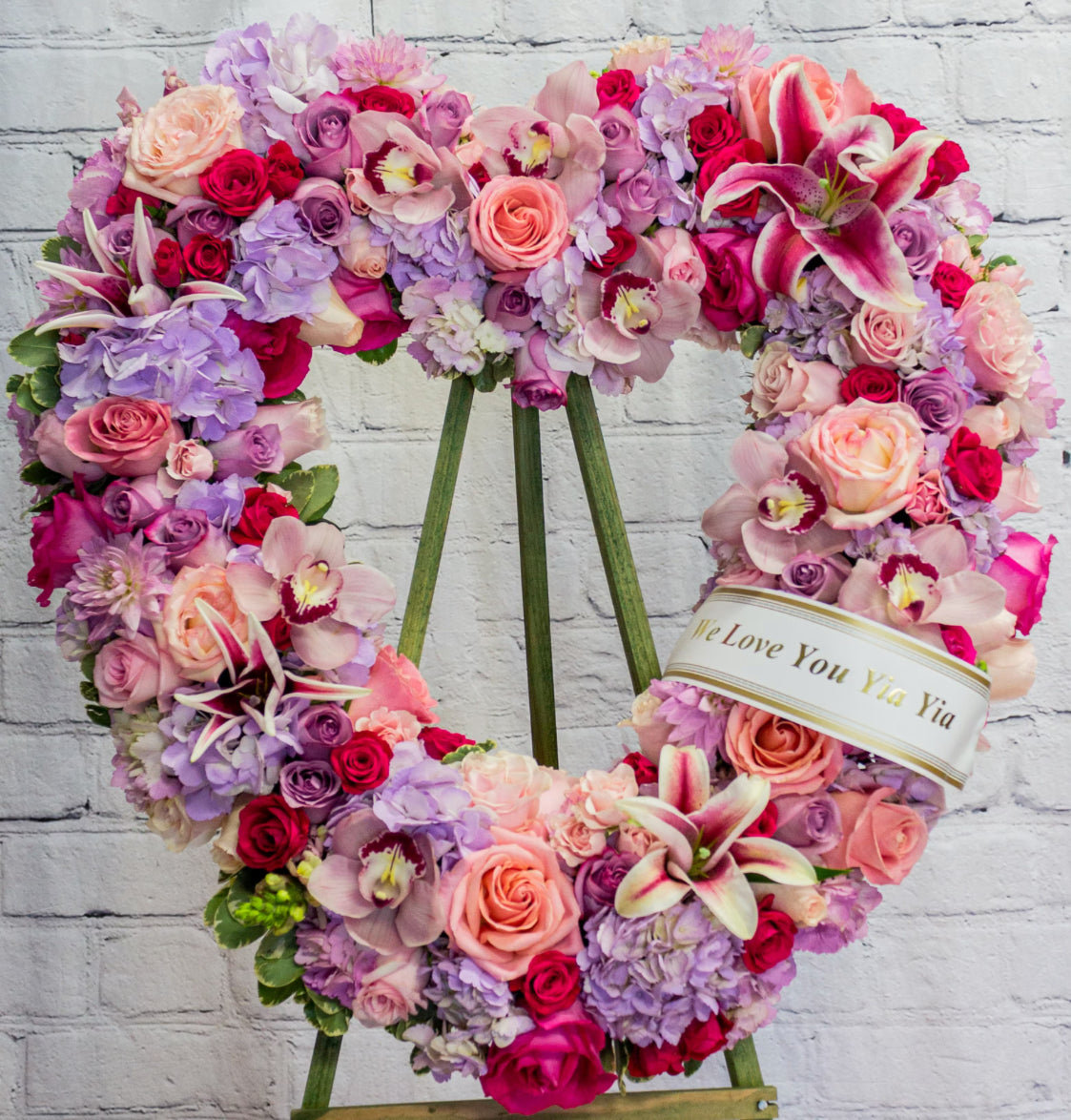Heart-shaped floral wreath with pink roses, orchids, hydrangeas, and stargazer lilies symbolizing love and remembrance – Garden of Remembrance by 1800 Blooms Bronx NY