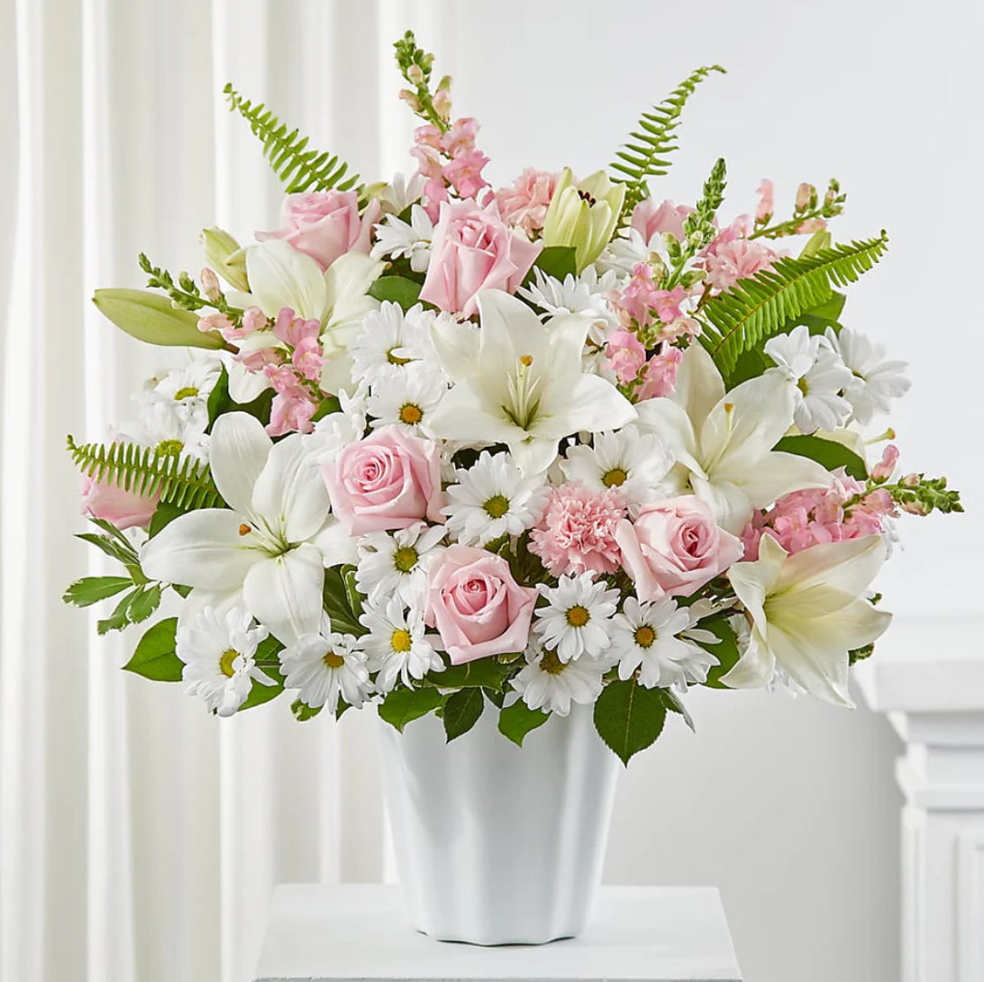 lilies, daisies, and carnations in a white vase