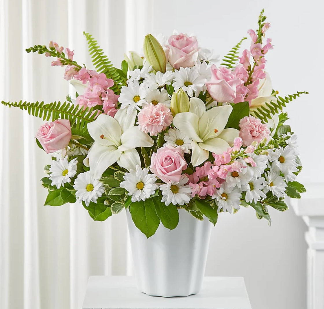 Pastel pink and white floral arrangement with roses, lilies, daisies, and carnations in a white vase – Graceful Elegance by 1800 Blooms Bronx NY
