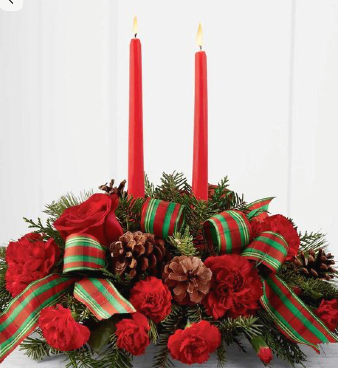 Winter-themed centerpiece with white blooms, pine cones, evergreens and Christmas ornaments